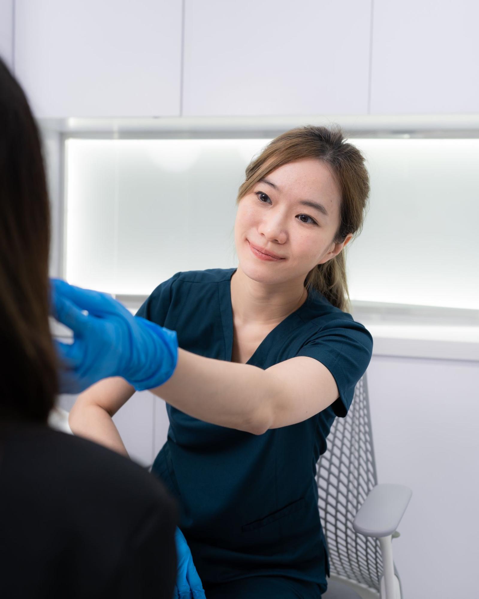 Doctor evaluating patient’s face by Dr. Tanisa Suphattarakul